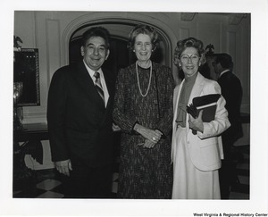 ["Blanchette Rockefeller (center) standing with two guests of Governor Jay Rockefellers at the Governor's Mansion on inauguration day."]%